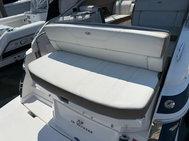 Slide: The Image of 2017 Regal 28 Express boat with white cushioned seating at the stern. - 15