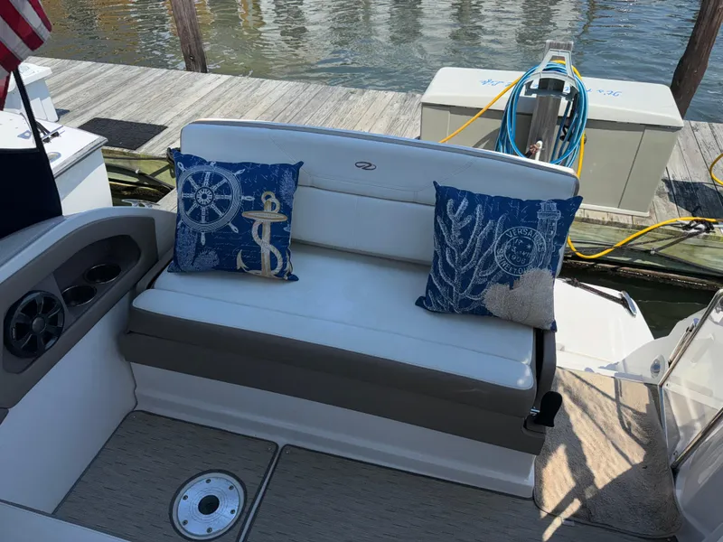 Slide: The Image of 2017 Regal 28 Express boat interior with nautical-themed cushions by the dock. - 19