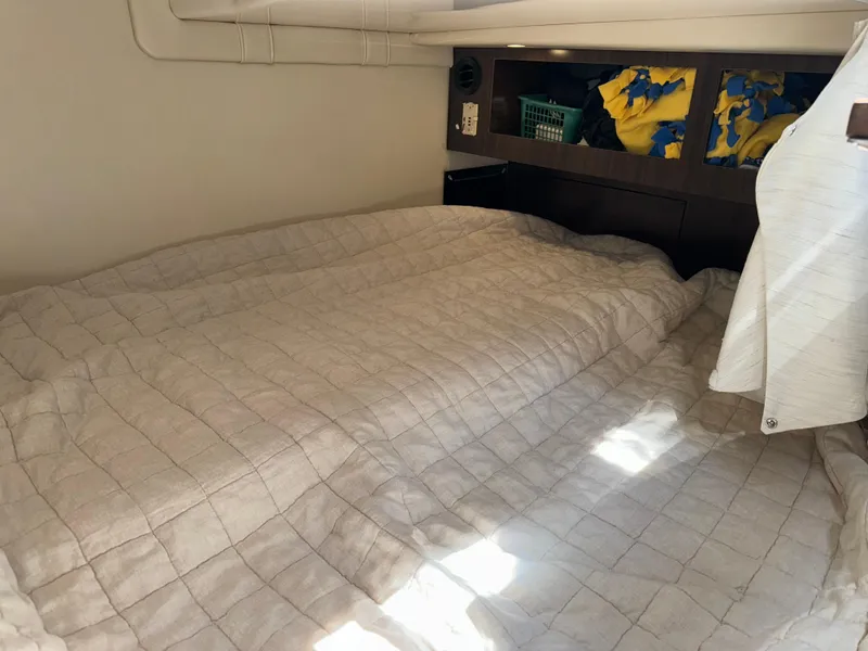 Slide: The Image of Cozy cabin bed in 2017 Regal 28 Express boat with storage shelves. - 49