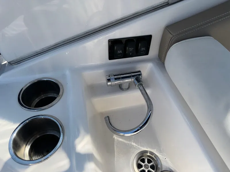 Slide: The Image of 2017 Regal 28 Express boat sink with faucet and cup holders. - 28