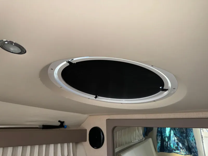 Slide: The Image of 2017 Regal 28 Express cabin interior with ceiling hatch and curtains. - 44