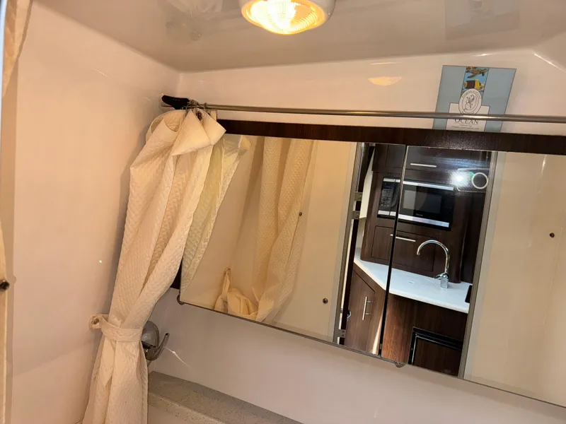 Slide: The Image of Bathroom interior of 2017 Regal 28 Express boat with mirror and curtain. - 48