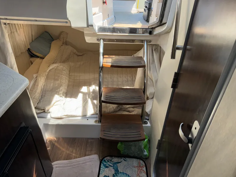 Slide: The Image of Interior cabin of 2017 Regal 28 Express boat with cozy bed and wooden steps. - 46