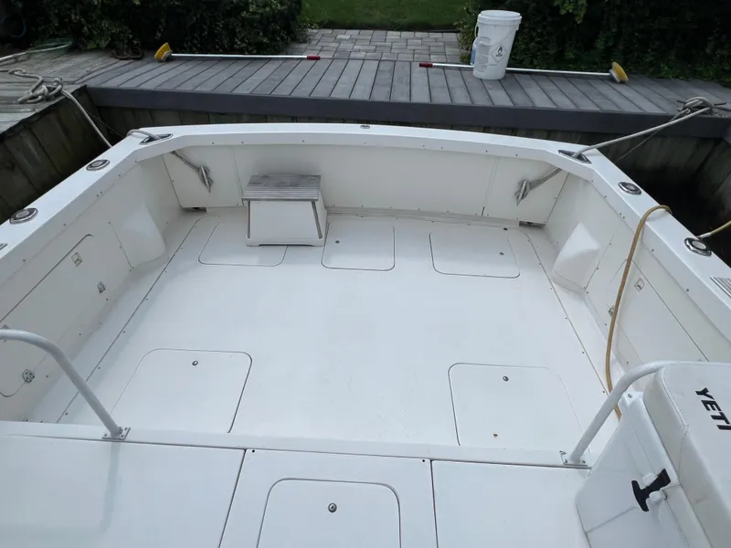 Slide: The Image of 1990 Bertram 28 Flybridge boat deck with storage compartments and seating. - 12