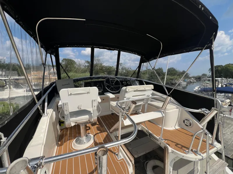 Slide: The Image of 1990 Bertram 28 Flybridge boat interior with helm, seating, and canopy. - 14