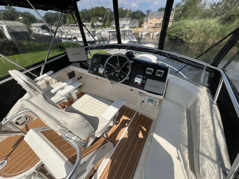 Slide: The Image of 1990 Bertram 28 Flybridge interior with helm, seating, and navigation equipment. - 15