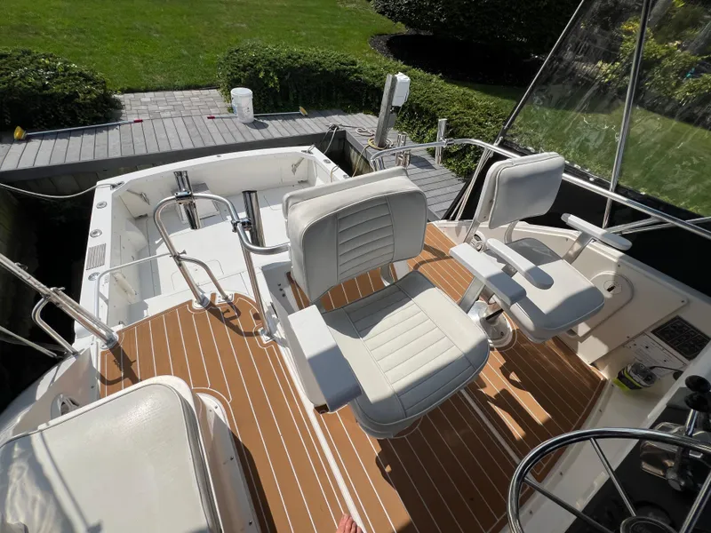 Slide: The Image of 1990 Bertram 28 Flybridge boat interior with white seating and wooden deck. - 16