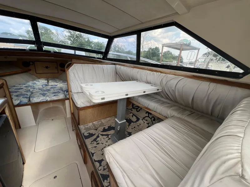 Slide: The Image of Interior of a 1990 Bertram 28 Flybridge boat with cushioned seating and table. - 2