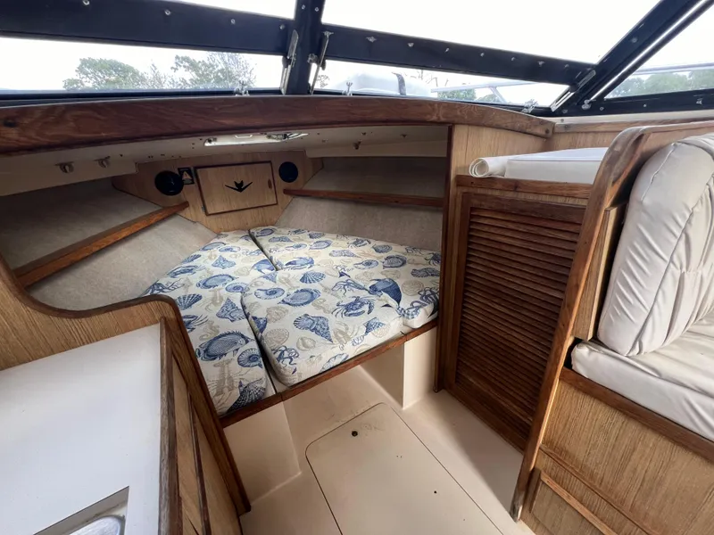 Slide: The Image of Interior of a 1990 Bertram 28 Flybridge boat with nautical-themed bedding. - 28