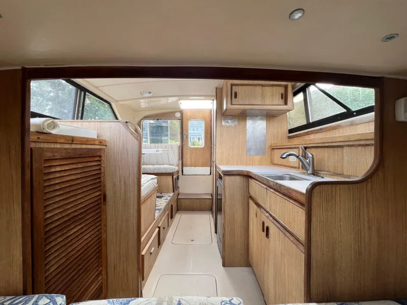 Slide: The Image of Interior of a 1990 Bertram 28 Flybridge boat with wood cabinetry and compact kitchen area. - 3