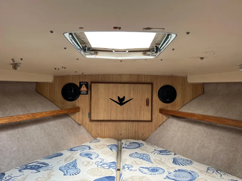 Slide: The Image of Interior cabin of a 1990 Bertram 28 Flybridge boat with nautical-themed bedding. - 35