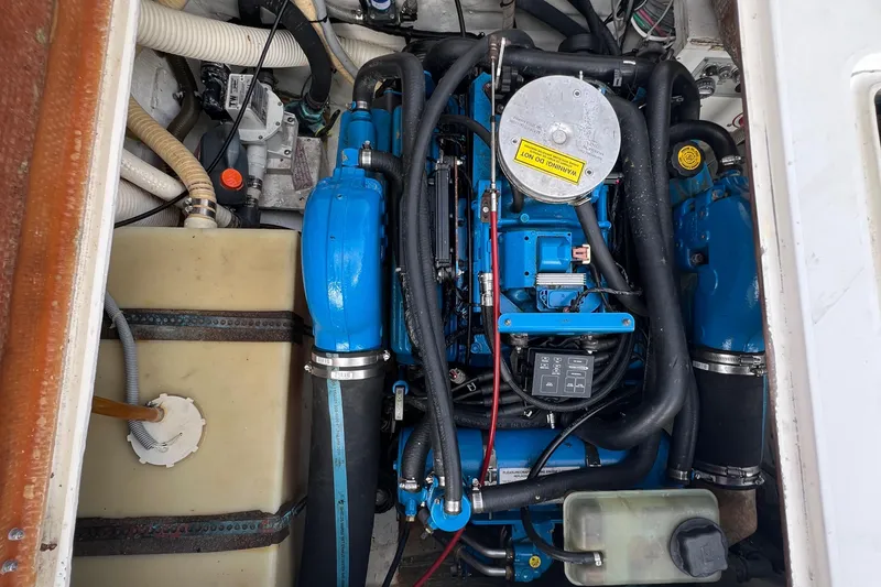 Slide: The Image of Engine compartment of a 1990 Bertram 28 Flybridge boat, showcasing blue engine components. - 38