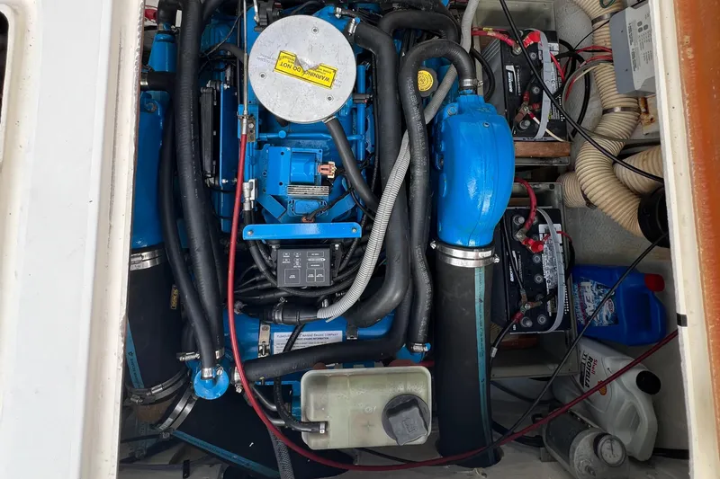 Slide: The Image of Engine compartment of a 1990 Bertram 28 Flybridge boat, featuring blue components and wiring. - 40