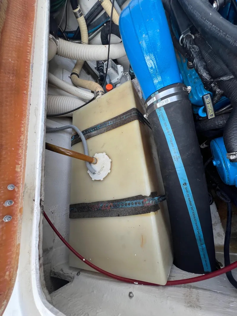 Slide: The Image of Engine compartment of a 1990 Bertram 28 Flybridge, showing hoses and a fuel tank. - 44