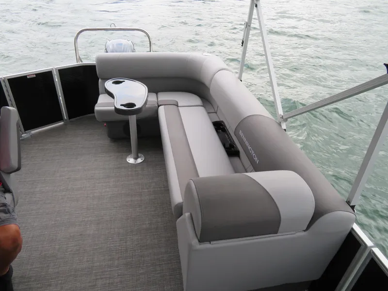 Slide: The Image of 2025 Bennington 20SVL-SPS pontoon boat interior with gray seating and table on water. - 11