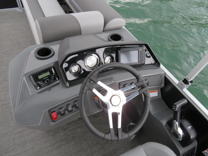 Slide: The Image of 2025 Bennington 20SVL-SPS boat dashboard with steering wheel and control panel on water. - 14