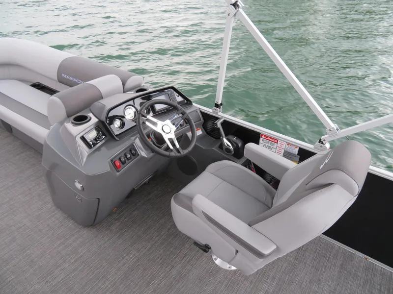 Slide: The Image of 2025 Bennington 20SVL-SPS boat interior with steering console and seating on water. - 15
