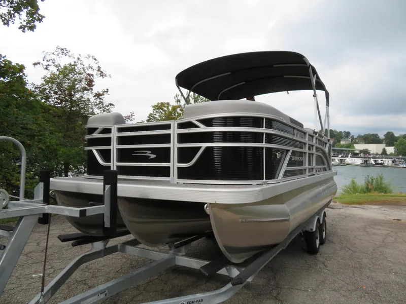 Slide: The Image of 2025 Bennington 20SVL-SPS pontoon boat on trailer by a lake. - 5