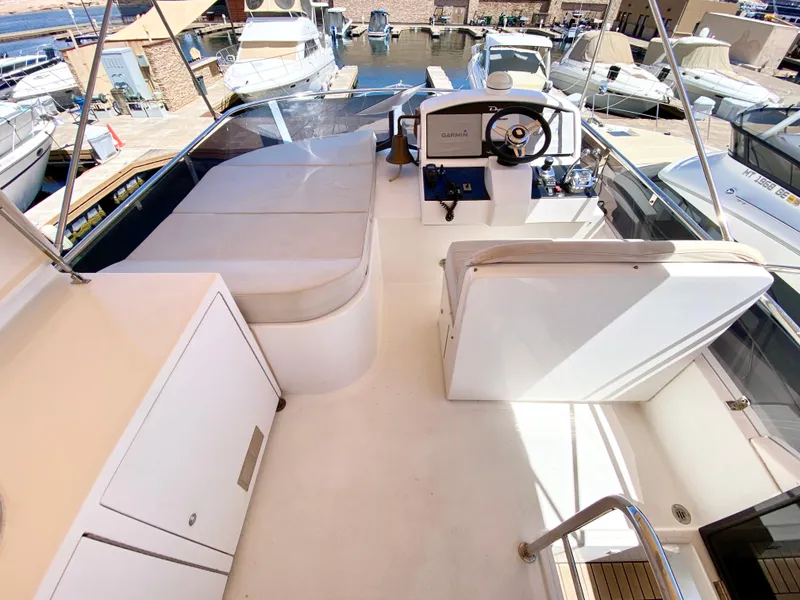 Slide: The Image of 2014 Dyna 52 yacht helm with marina view, featuring sleek white design and modern controls. - 16