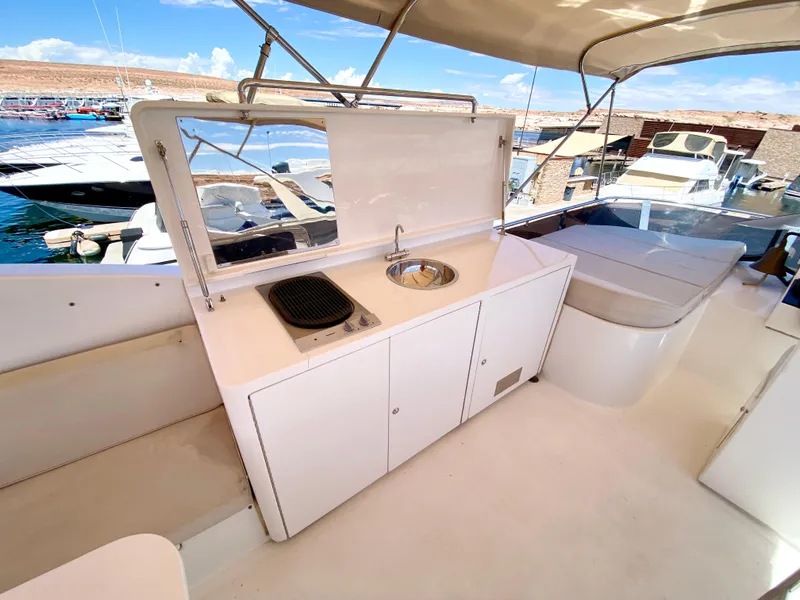 Slide: The Image of 2014 Dyna 52 yacht deck with kitchenette and seating area. - 18