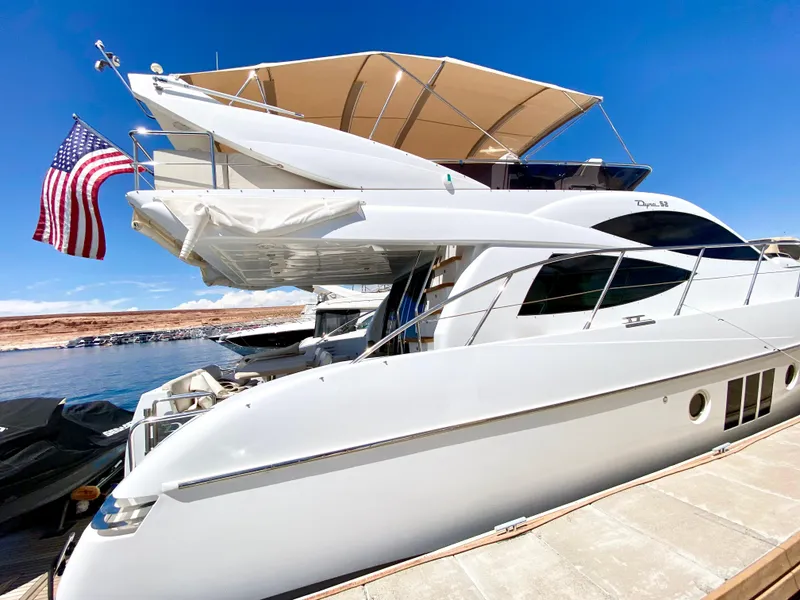 Slide: The Image of Luxurious 2014 Dyna 52 yacht docked, featuring sleek design and American flag. - 22
