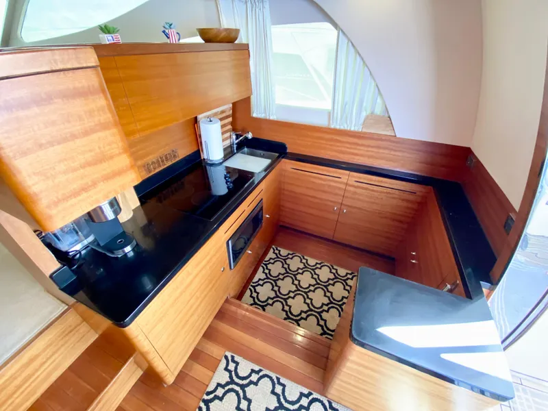 Slide: The Image of Luxurious 2014 Dyna 52 yacht kitchen with wood cabinetry and black countertops. - 26