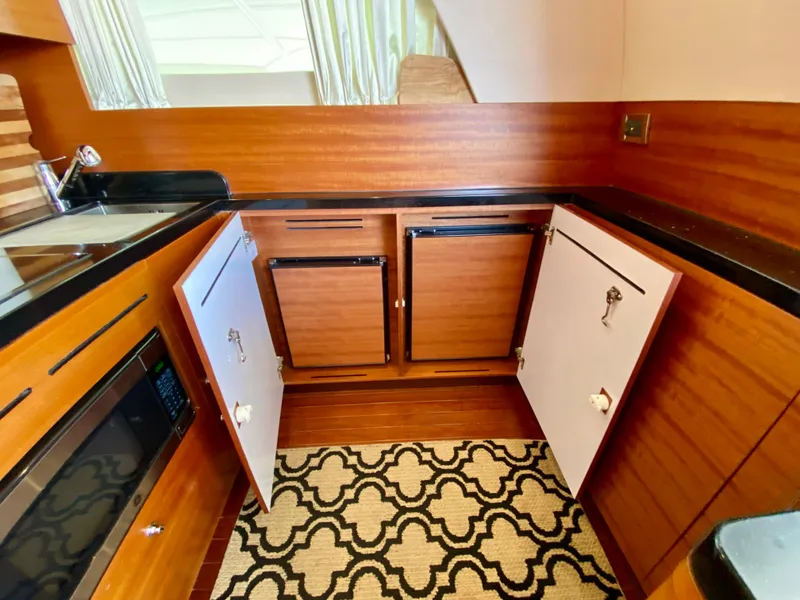 Slide: The Image of 2014 Dyna 52 yacht kitchen with wood cabinets and modern appliances. - 28