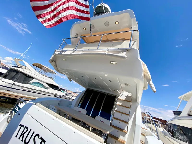 Slide: The Image of Luxury 2014 Dyna 52 yacht with American flag, docked under clear blue sky. - 6