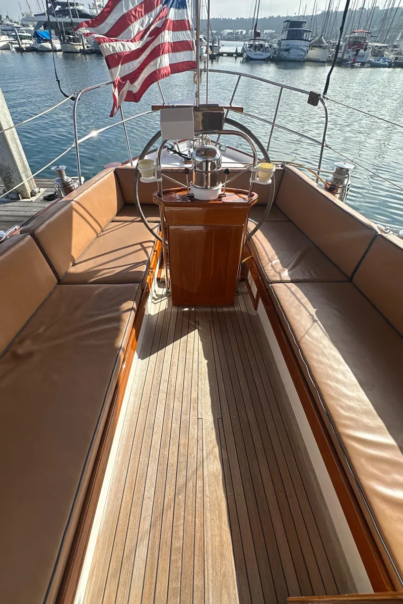 Slide: The Image of 1969 Calkins 50 Pilot House sailboat with wooden accents docked in a marina. - 13