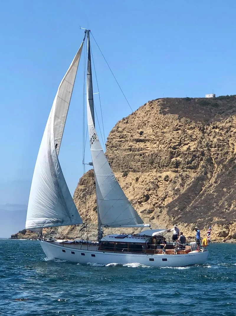 Slide: The Image of 1969 Calkins 50 Pilot House sailboat docked at marina under cloudy sky. - 2