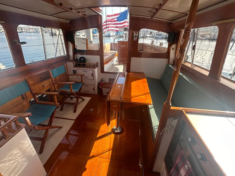 Slide: The Image of Interior of a 1969 Calkins 50 Pilot House boat with wooden furnishings and American flag. - 27