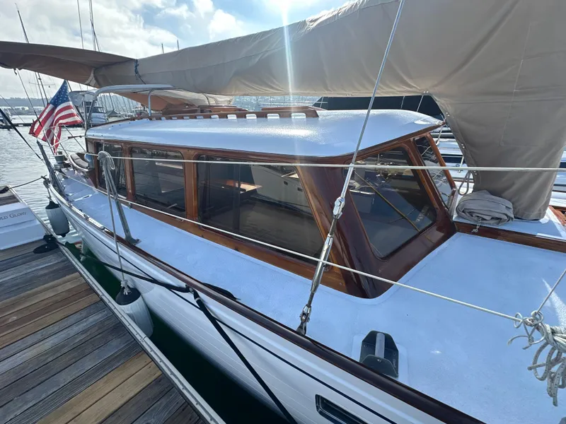 Slide: The Image of 1969 Calkins 50 Pilot House yacht docked, featuring wooden accents and an American flag. - 31