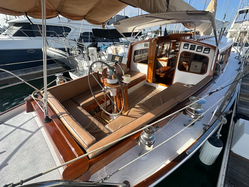 Slide: The Image of 1969 Calkins 50 Pilot House yacht docked, featuring wooden accents and an American flag. - 4