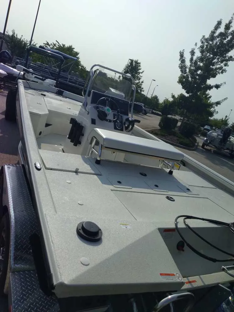 Slide: The Image of 2024 Ranger RB200 boat on trailer, parked outdoors, featuring spacious deck and console. - 2
