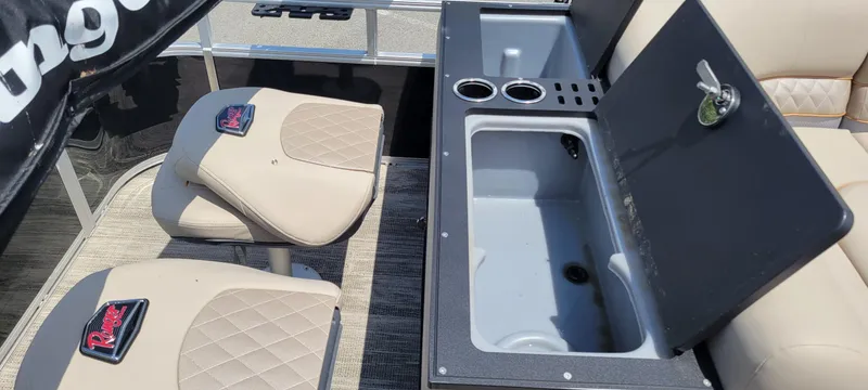 Slide: The Image of 2024 Ranger Reata 223FC boat interior with beige seats and open storage compartment. - 5