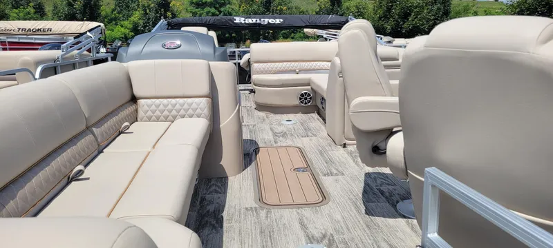 Slide: The Image of 2024 Ranger Reata 223FC pontoon boat interior with beige seating and wood-style flooring. - 7