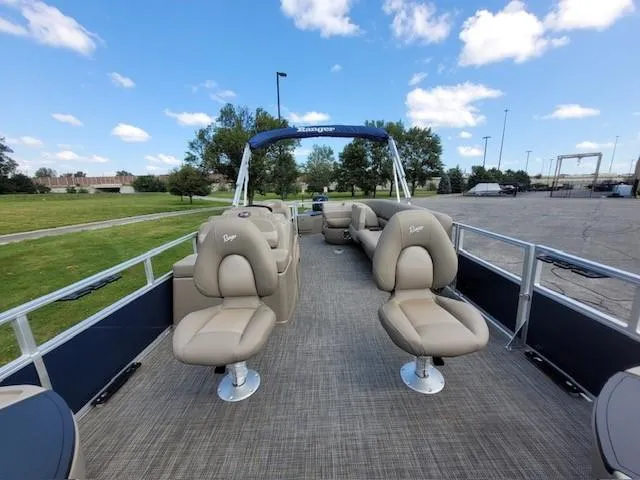 Slide: The Image of 2024 Ranger Reata 200F pontoon boat with beige seating and open deck. - 5