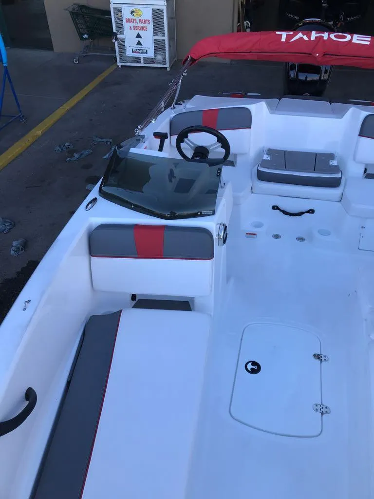 Slide: The Image of 2024 Tahoe T18 boat interior with red and gray accents, steering wheel, and seating. - 10