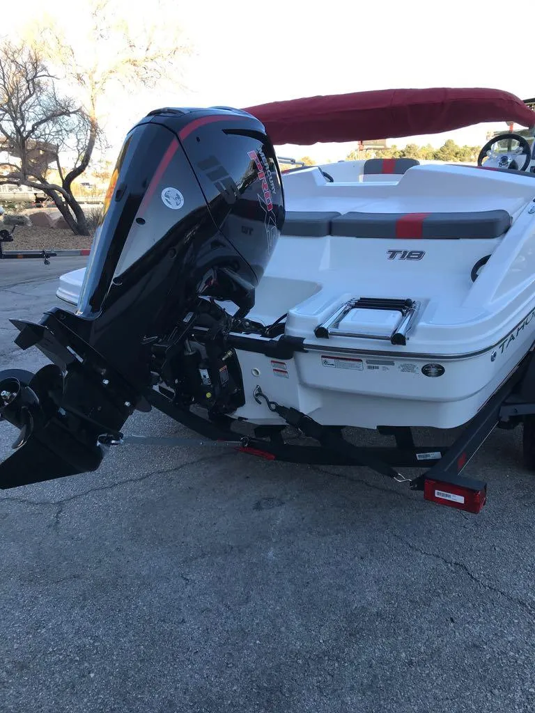 Slide: The Image of 2024 Tahoe T18 boat with outboard motor, parked on a trailer. - 2