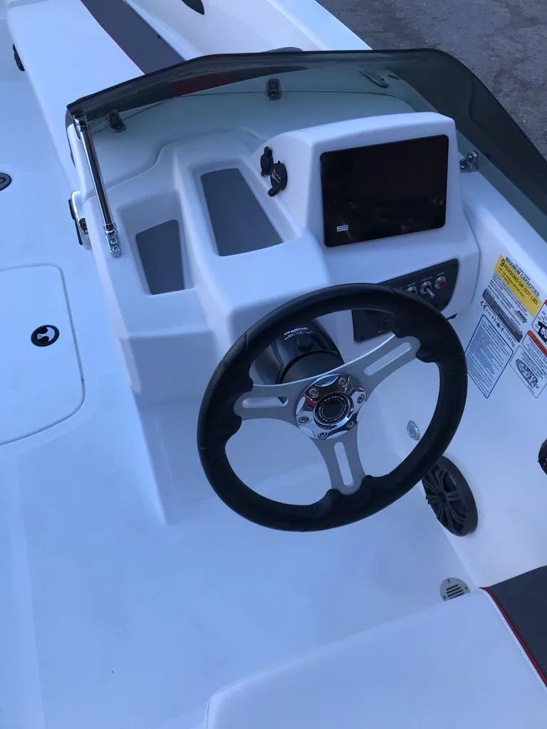 Slide: The Image of 2024 Tahoe T18 boat dashboard with steering wheel and control panel. - 6