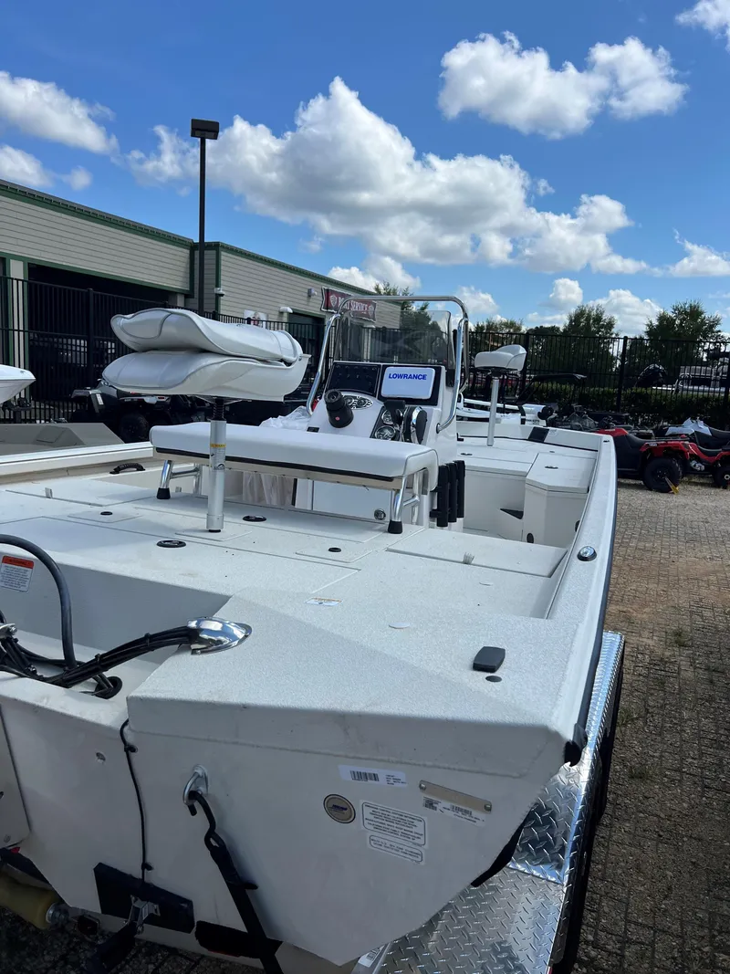 Slide: The Image of 2024 Ranger RB200 boat, white exterior, parked outdoors under a blue sky with clouds. - 2
