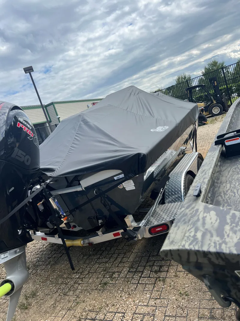 Slide: The Image of 2024 Ranger RB200 boat covered on a trailer, parked outdoors under a cloudy sky. - 6