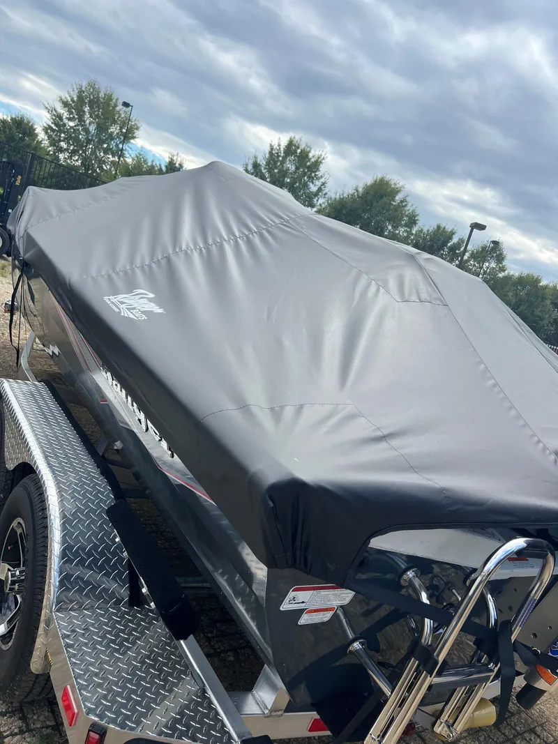 Slide: The Image of 2024 Ranger RB200 boat covered on trailer under cloudy sky. - 7