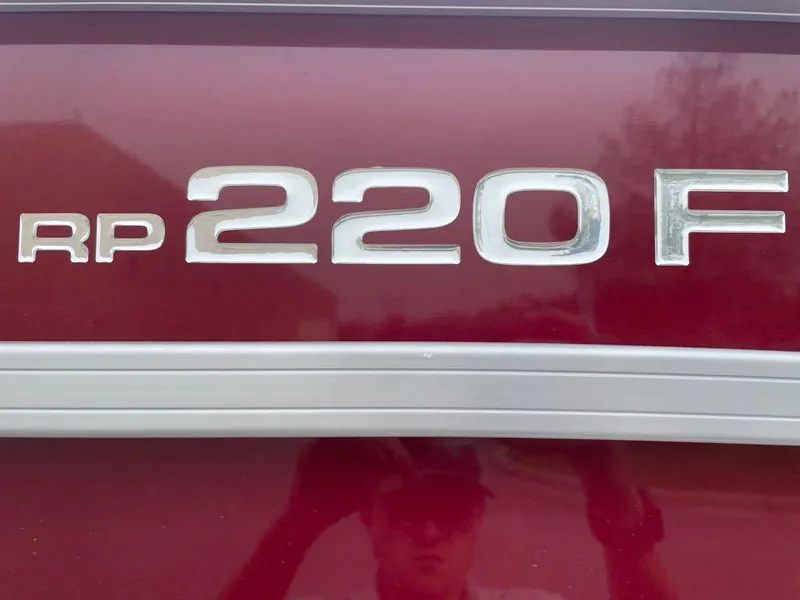 Slide: The Image of Close-up of 2024 Ranger Reata 220F model emblem on a red surface. - 2