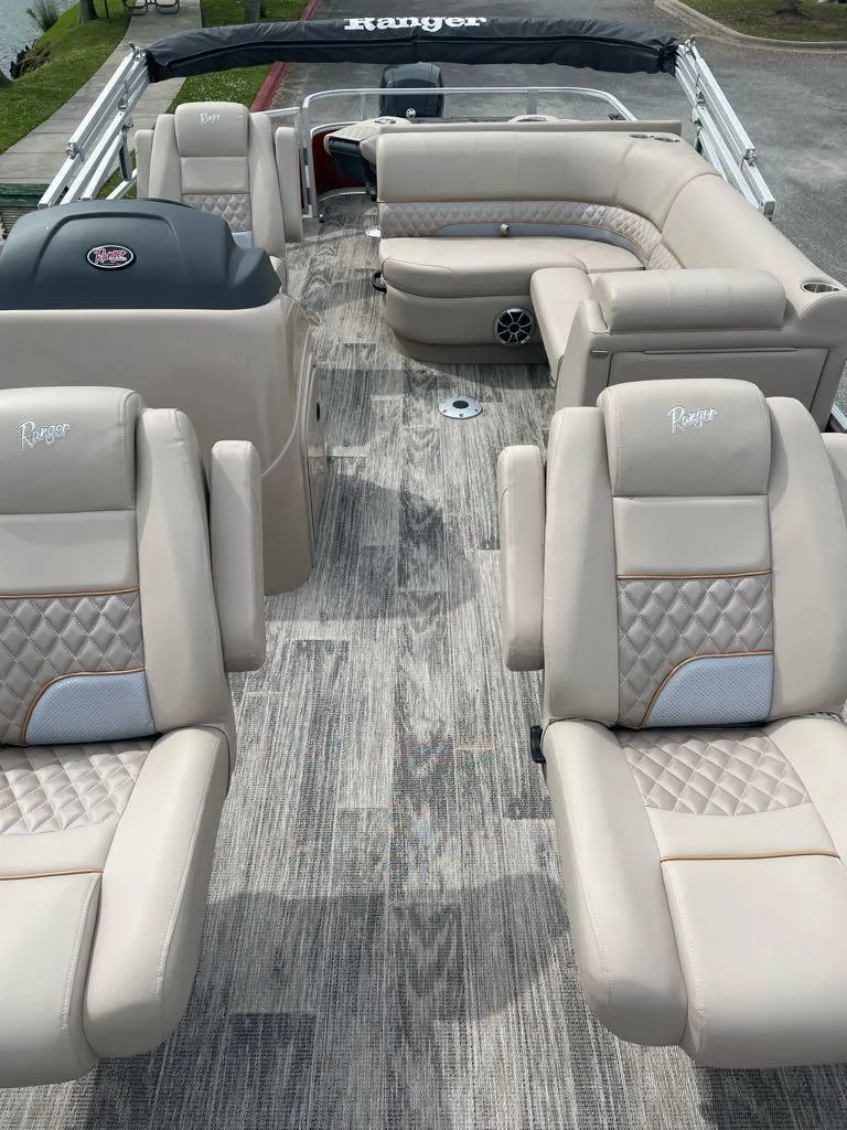 Slide: The Image of 2024 Ranger Reata 220F boat interior with beige seating and wood-style flooring. - 4