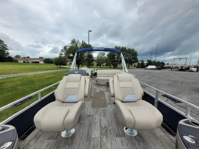 Slide: The Image of 2024 Ranger Reata 223F boat with plush seating and open deck, under cloudy skies. - 5