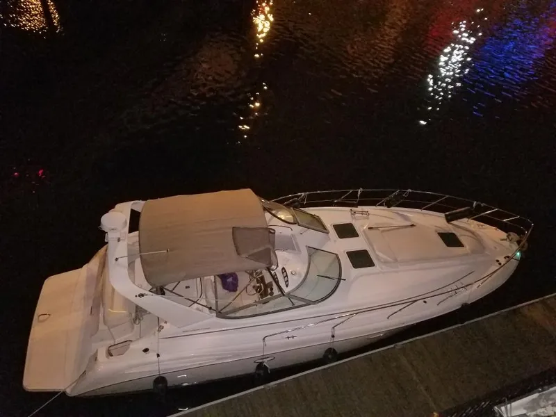 Slide: The Image of 1998 Silverton 360 Express yacht docked at night with reflections on water. - 4