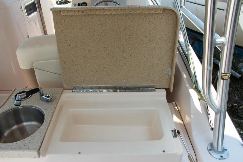Slide: The Image of 2014 Grady-White Freedom 307 boat interior with sink and storage compartment. - 18