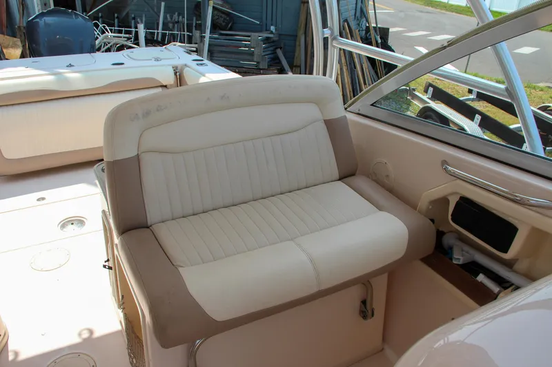 Slide: The Image of 2014 Grady-White Freedom 307 boat interior with beige seating and helm area. - 38