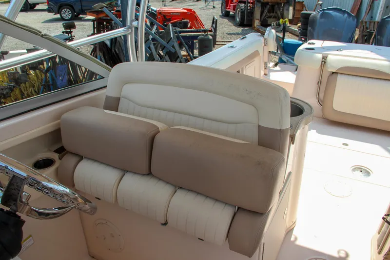 Slide: The Image of 2014 Grady-White Freedom 307 boat interior with cushioned seating and steering wheel. - 39